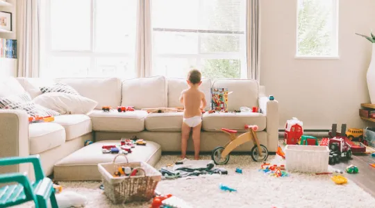 Boy playing with scattered toys everywhere