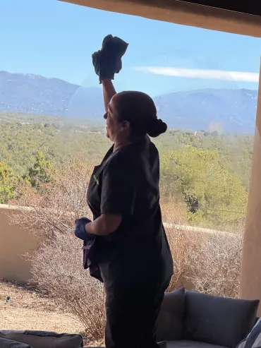 team member cleaning a window