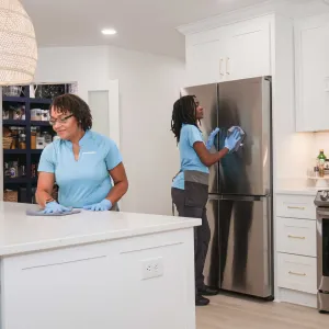 Two Merry Maids team members cleaning kitchen
