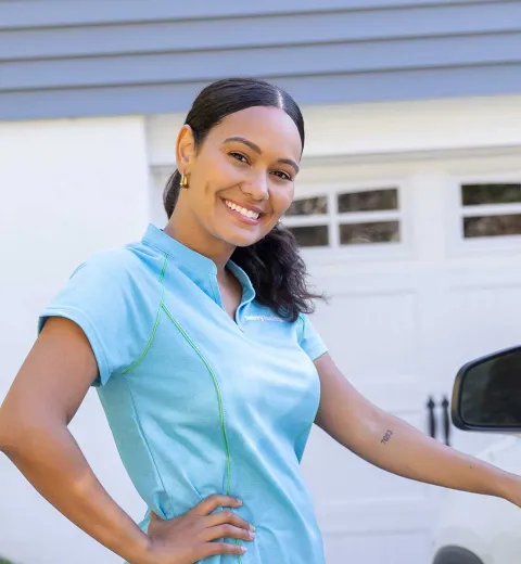 Merry Maids team member next to car