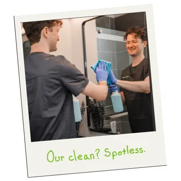 Merry Maids of Berks County cleaner smiling while wiping a bathroom mirror spotless