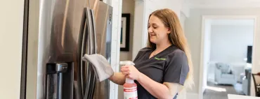 Merry Maids team member cleaning kitchen appliances